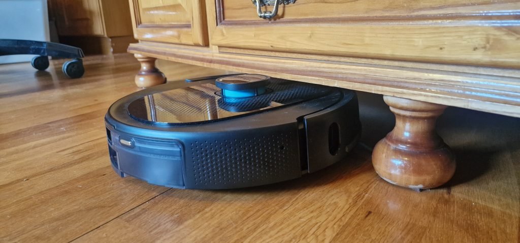 Foto del robot aspirador chocando con la parte del láser en la parte inferior de un armario